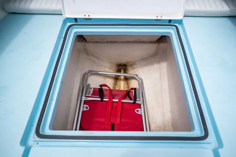 Slide: The Image of Open storage compartment on 2018 Dorado 25 SE boat with red bag inside. - 23
