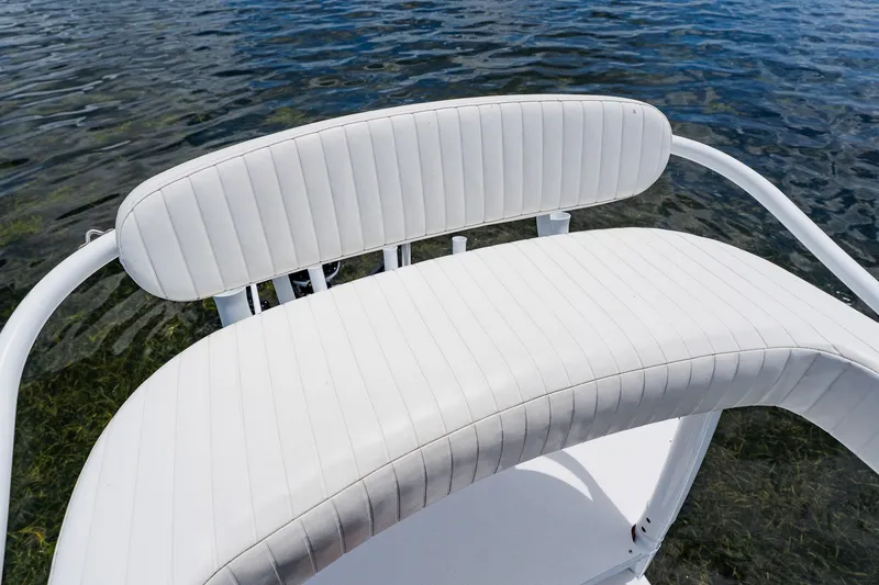 Slide: The Image of White cushioned seat on 2018 Dorado 25 SE boat, overlooking clear water. - 46