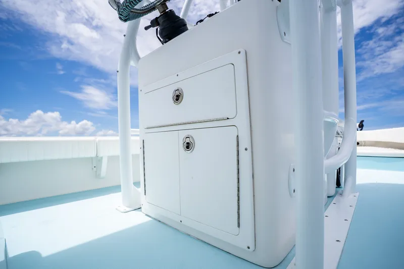 Slide: The Image of 2018 Dorado 25 SE boat console with storage compartments under a clear blue sky. - 36