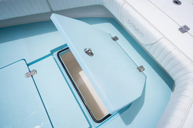 Slide: The Image of Open storage compartment on 2018 Dorado 25 SE boat, featuring light blue interior. - 18