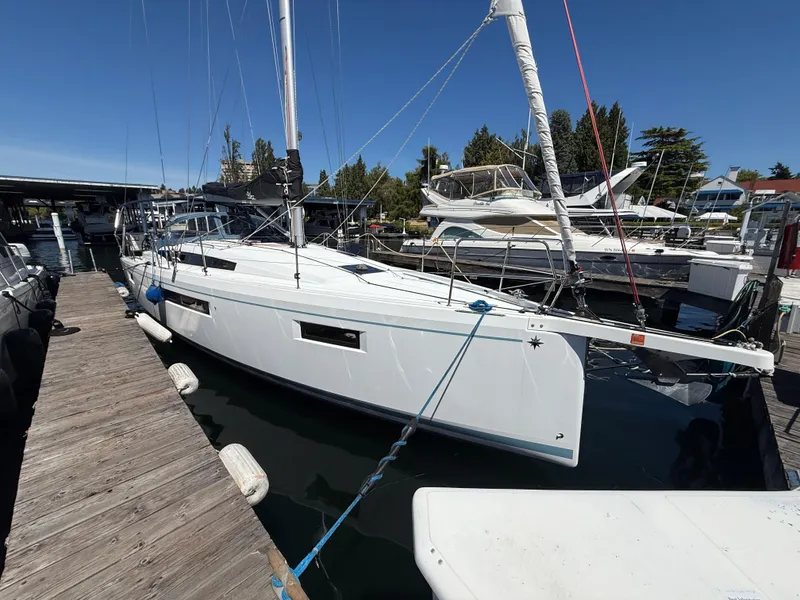 The Image of 2021 Jeanneau Sun Odyssey 410 sailboat docked at marina under clear blue sky. - 0