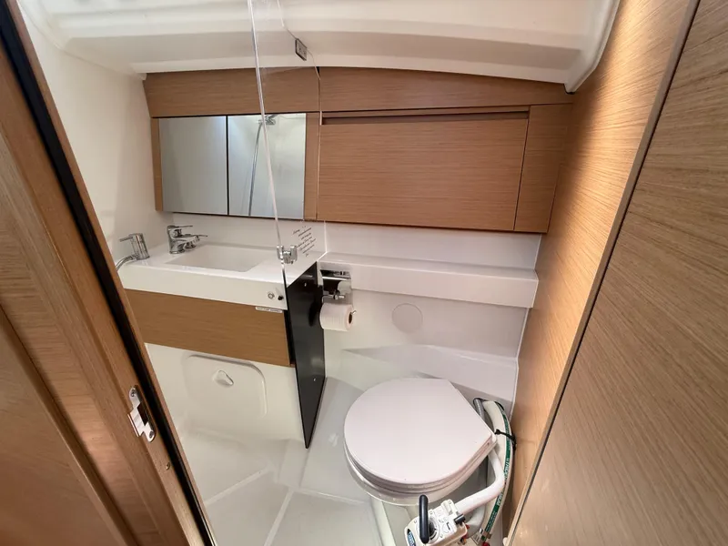 Slide: The Image of Modern bathroom in 2021 Jeanneau Sun Odyssey 410 yacht with wood accents and compact design. - 14