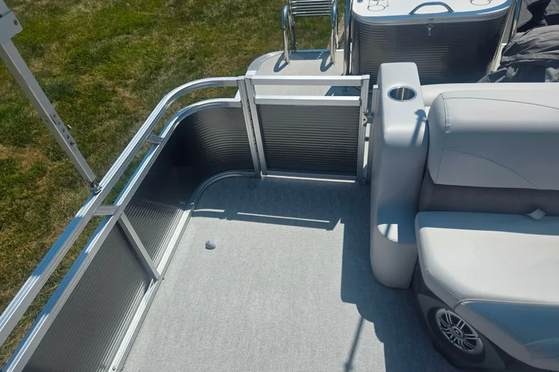 Slide: The Image of 2020 Avalon LSZ Cruise Rear Bench boat interior with seating and railing, on grassy background. - 15