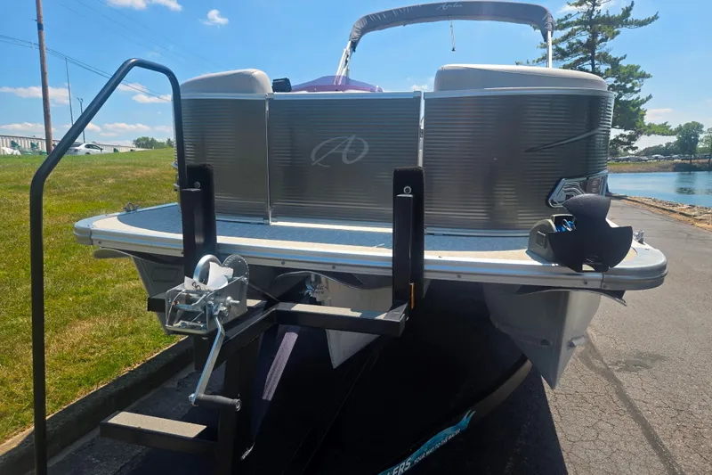 Slide: The Image of 2020 Avalon LSZ Cruise Rear Bench pontoon boat on trailer, sunny day, lakeside view. - 6
