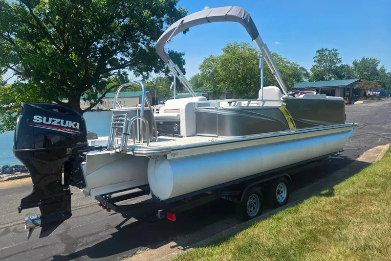 Slide: The Image of 2020 Avalon LSZ Cruise Rear Bench pontoon boat on trailer, featuring Suzuki outboard motor. - 1
