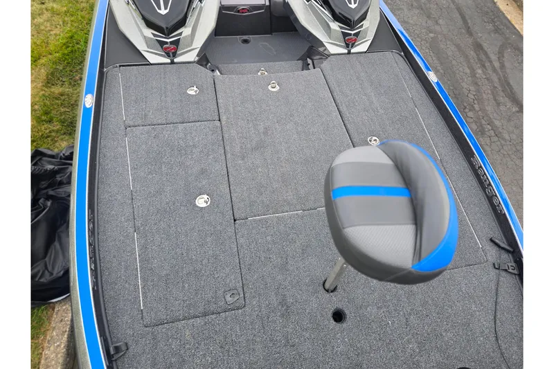 Slide: The Image of 2023 Ranger Z521R boat deck with gray carpet and blue-accented seat. - 15