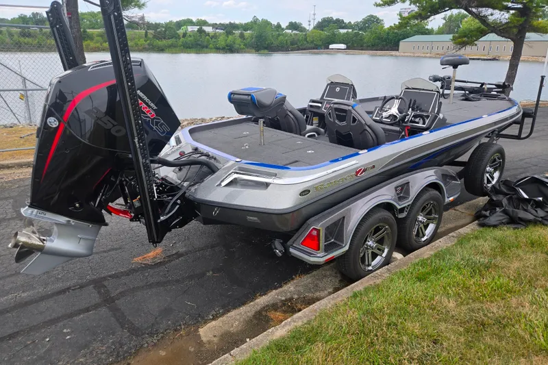Slide: The Image of 2023 Ranger Z521R boat with powerful engine, parked near a scenic lake. - 1