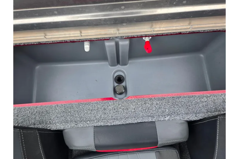 Slide: The Image of 2023 Tracker Pro Team 175 TXW boat storage compartment with gray interior and red accents. - 21
