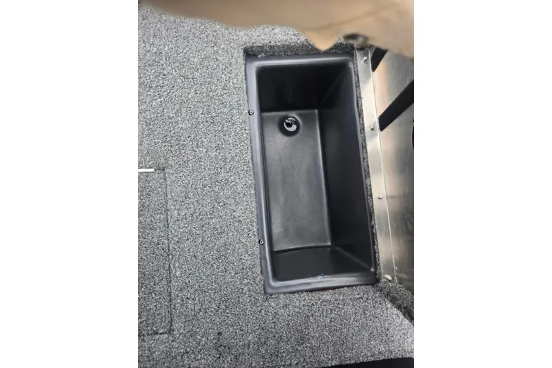 Slide: The Image of 2023 Tracker Pro Team 175 TXW boat storage compartment with gray carpeted interior. - 22