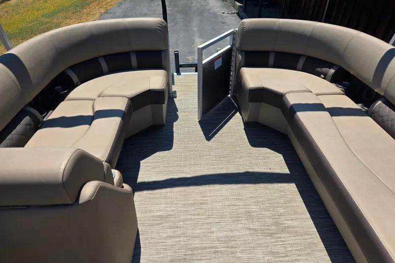 Slide: The Image of 2022 Bennington L24 pontoon boat interior with beige seating and open gate. - 19