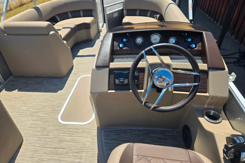 Slide: The Image of 2022 Bennington L24 pontoon boat interior with steering wheel and seating area. - 22