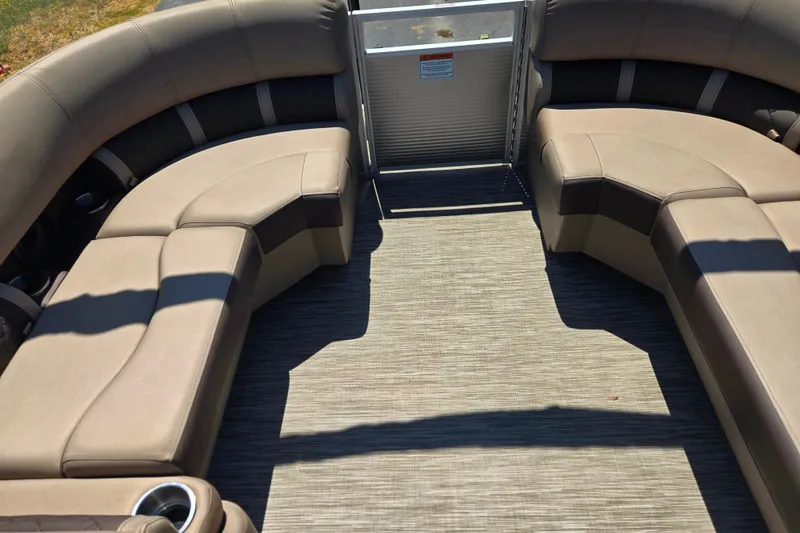 Slide: The Image of 2022 Bennington L24 pontoon boat interior with beige seating and carpeted floor. - 13