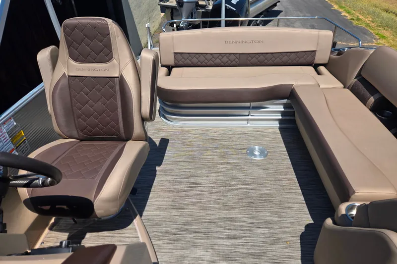 Slide: The Image of 2022 Bennington L24 boat interior with beige and brown seating, showcasing luxury design. - 18