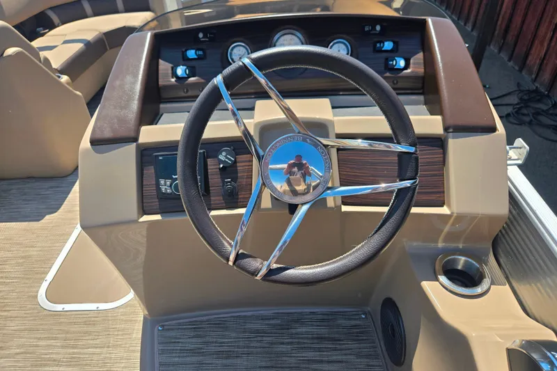 Slide: The Image of Steering wheel of a 2022 Bennington L24 boat with dashboard controls. - 11