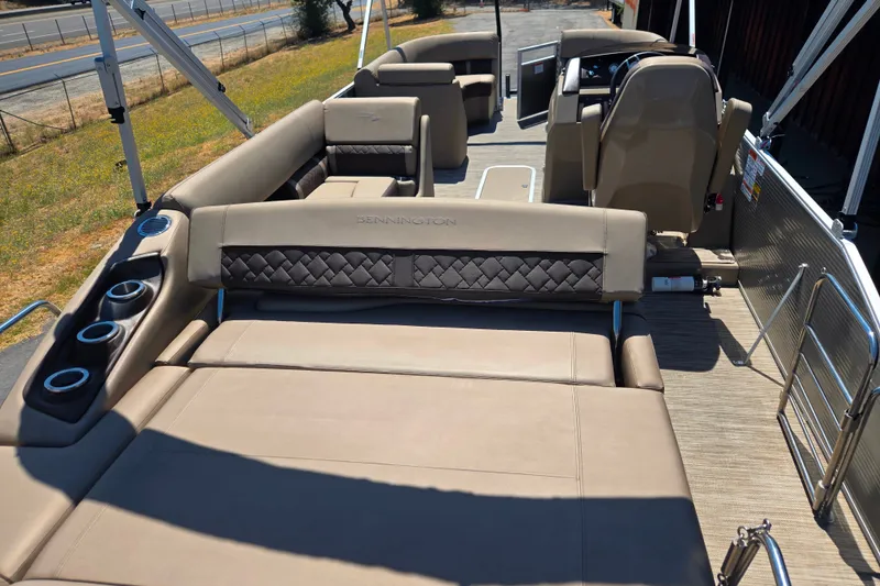 Slide: The Image of 2022 Bennington L24 pontoon boat interior with luxurious seating and cup holders. - 23