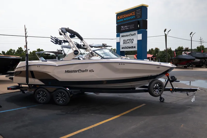 Slide: The Image of 2027 MasterCraft NXT23 boat on trailer at dealership, showcasing sleek design and modern features. - 10