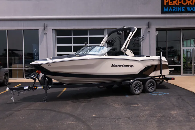 Slide: The Image of 2027 MasterCraft NXT23 boat on trailer outside dealership. - 2