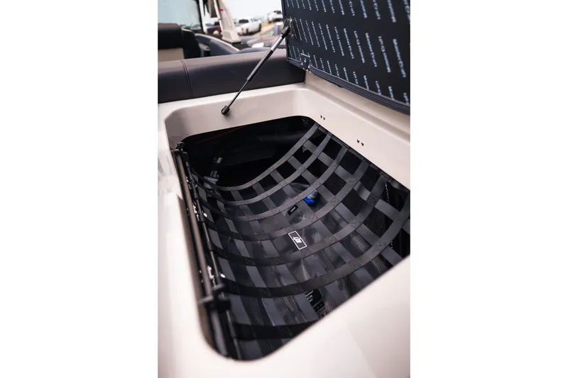 Slide: The Image of 2027 MasterCraft NXT23 boat storage compartment with open lid and netting. - 38