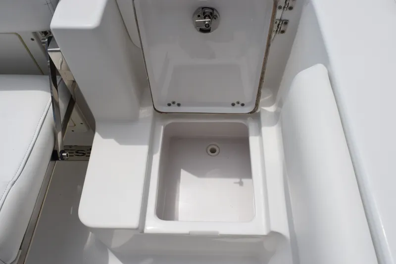 Slide: The Image of Open storage compartment on a 2015 Sportsman Open 212 Center Console boat. - 16