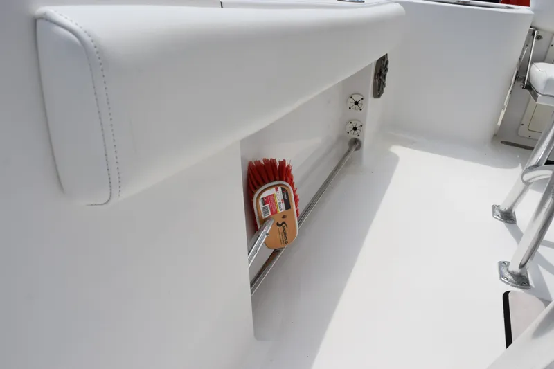 Slide: The Image of 2015 Sportsman Open 212 Center Console interior with storage and cleaning brush. - 14