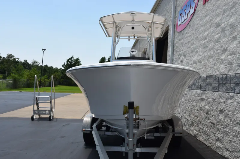 Slide: The Image of 2015 Sportsman Open 212 Center Console boat on trailer, parked outside a building. - 3