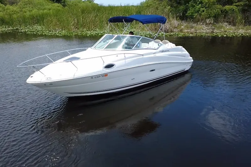 Slide: The Image of 2007 Sea Ray 240 Sundancer boat cruising on a calm river with lush greenery. - 15