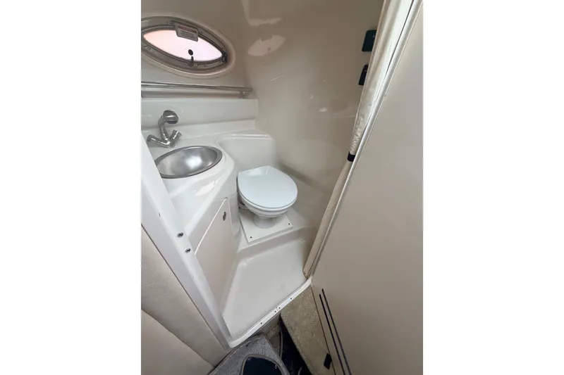 Slide: The Image of Compact bathroom in 2007 Sea Ray 240 Sundancer boat, featuring sink and toilet. - 24
