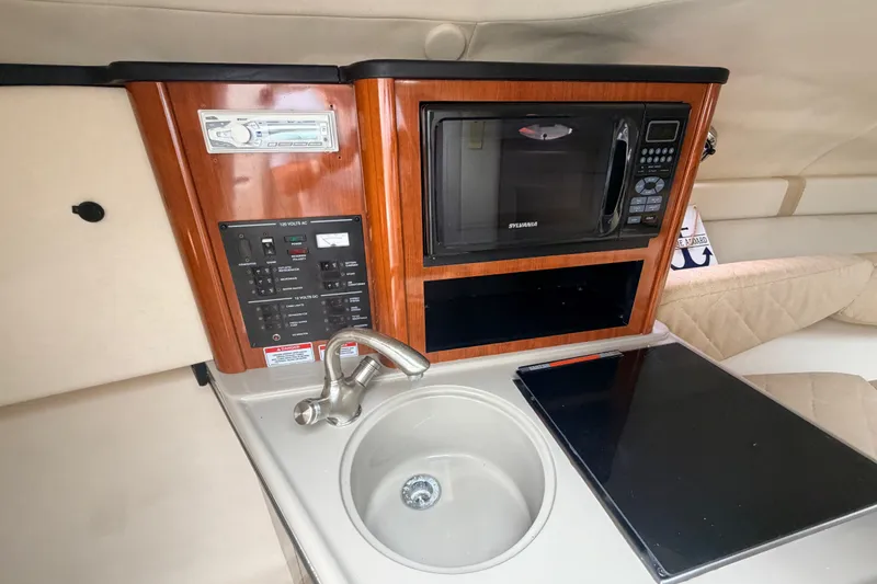Slide: The Image of 2007 Sea Ray 240 Sundancer cabin with microwave, sink, and control panel. - 26