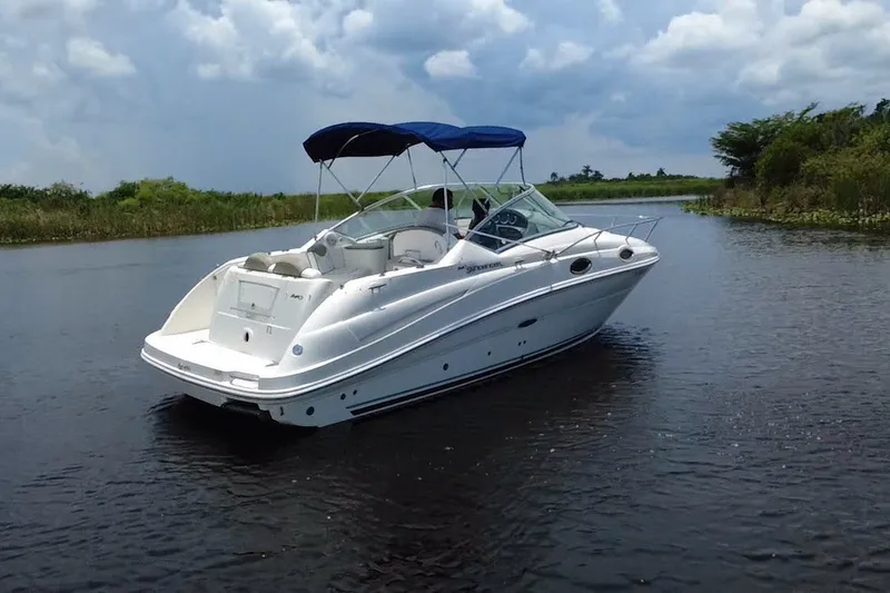 Slide: The Image of 2007 Sea Ray 240 Sundancer boat cruising on a calm river under a cloudy sky. - 7