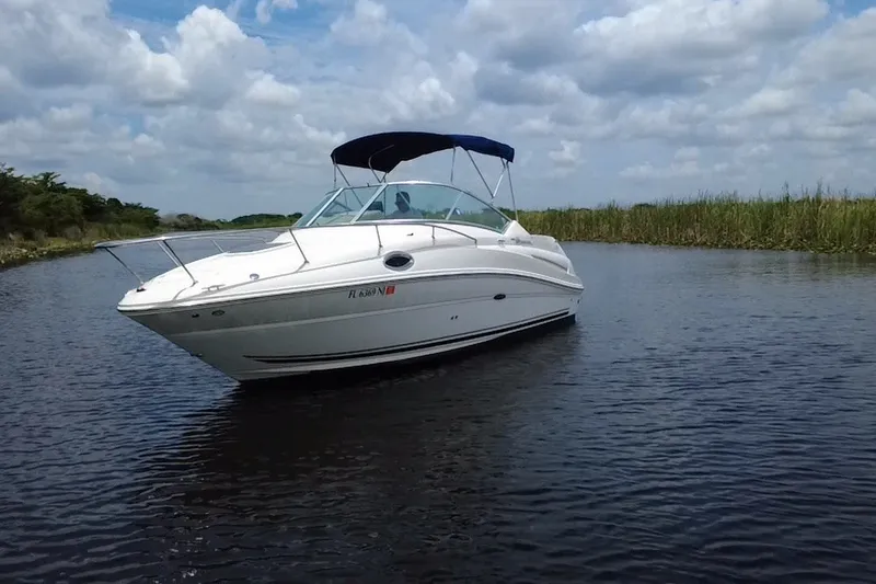 Slide: The Image of 2007 Sea Ray 240 Sundancer boat cruising on a calm lake under a cloudy sky. - 11
