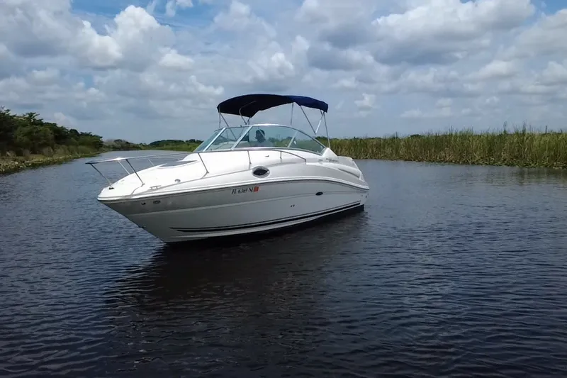 Slide: The Image of 2007 Sea Ray 240 Sundancer boat cruising on a calm waterway under a cloudy sky. - 9