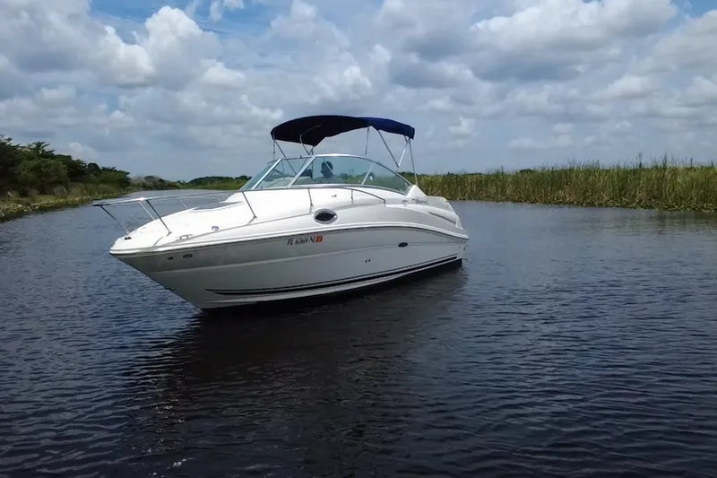 Slide: The Image of 2007 Sea Ray 240 Sundancer boat cruising on a calm waterway under a cloudy sky. - 8