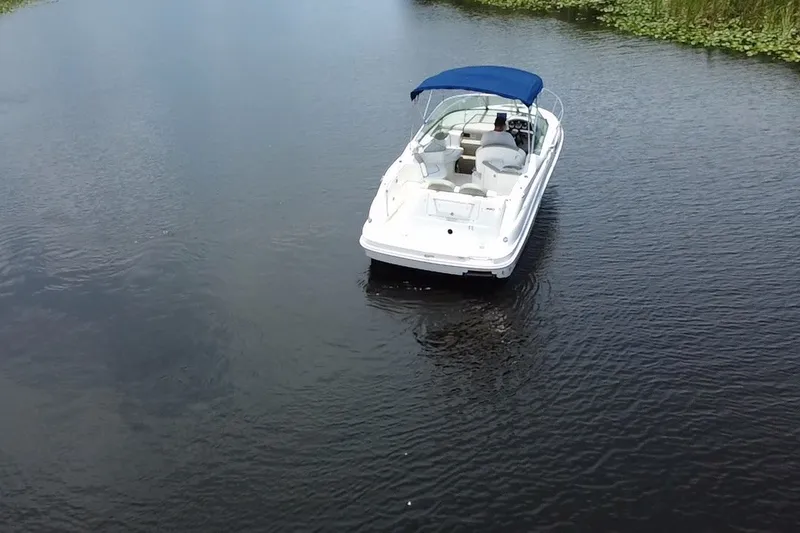 Slide: The Image of 2007 Sea Ray 240 Sundancer boat with blue canopy on calm water. - 3