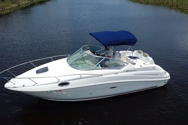 Slide: The Image of 2007 Sea Ray 240 Sundancer boat with blue canopy cruising on calm water. - 12
