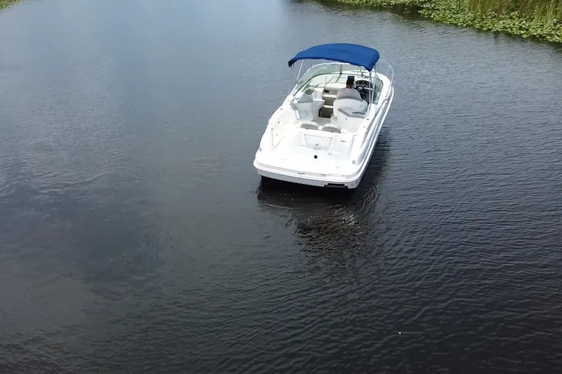 Slide: The Image of 2007 Sea Ray 240 Sundancer boat with blue canopy on calm water. - 4