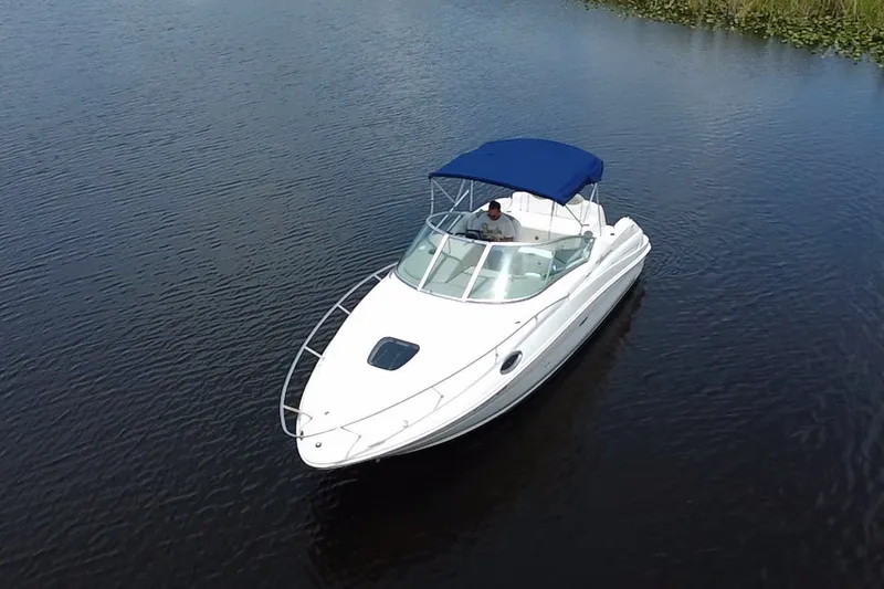 Slide: The Image of 2007 Sea Ray 240 Sundancer boat with blue canopy on calm water. - 14