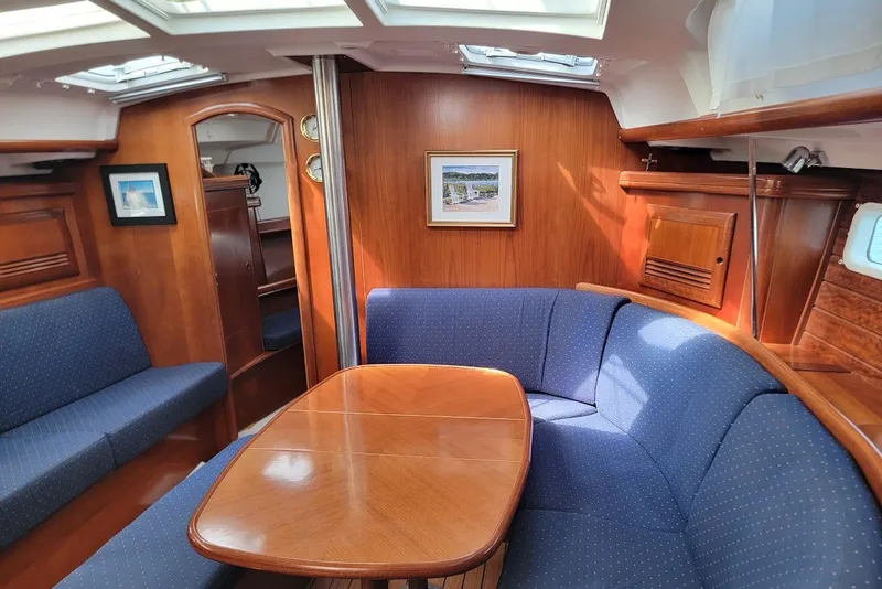 Slide: The Image of Interior of 2003 Beneteau 423 yacht with wooden finish and blue upholstered seating. - 1