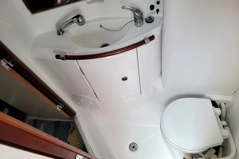 Slide: The Image of Bathroom interior of a 2003 Beneteau 423 yacht, featuring a sink and toilet. - 26
