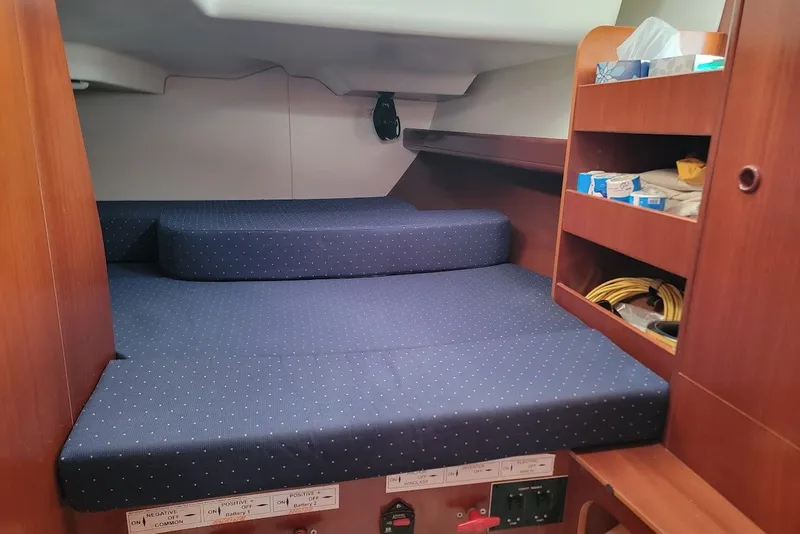 Slide: The Image of Cozy cabin interior of 2003 Beneteau 423 sailboat with blue cushions and wooden shelves. - 15