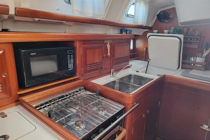 Slide: The Image of Galley kitchen in 2003 Beneteau 423 sailboat with stove, microwave, and sink. - 4