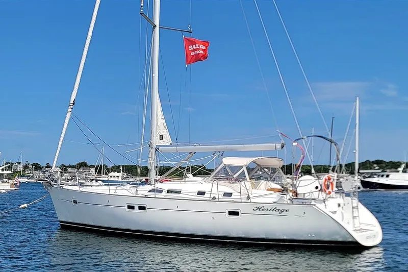 The Image of 2003 Beneteau 423 sailboat on water, clear sky, red flag, marina background. - 0