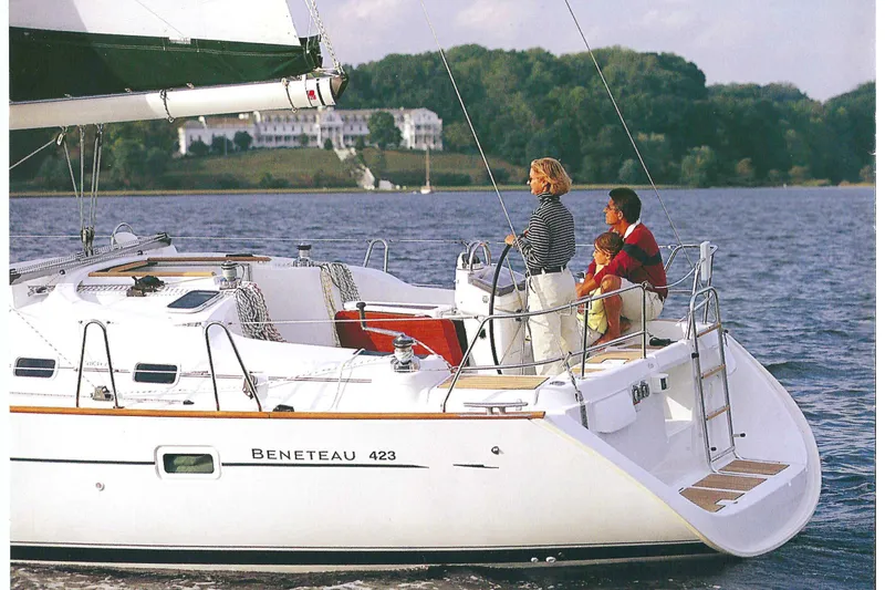 Slide: The Image of Family sailing on a 2003 Beneteau 423 yacht, enjoying a scenic water view. - 7