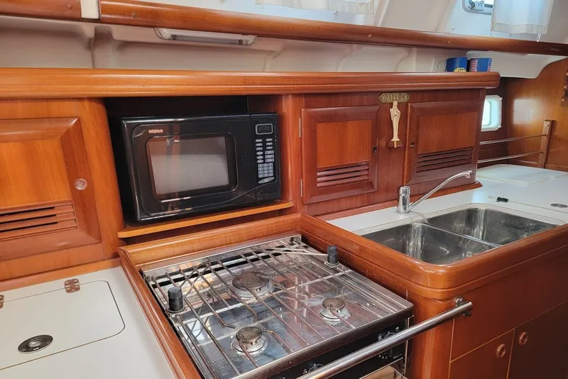 Slide: The Image of Galley kitchen in 2003 Beneteau 423 yacht with stove, microwave, and sink. - 30