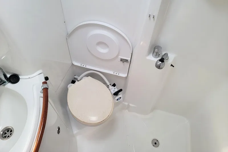 Slide: The Image of Bathroom interior of a 2003 Beneteau 423 yacht, featuring a compact toilet and sink. - 10