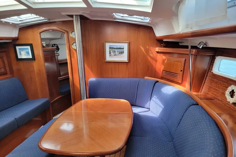 Slide: The Image of Interior of 2003 Beneteau 423 yacht with wooden finish and blue upholstered seating. - 6