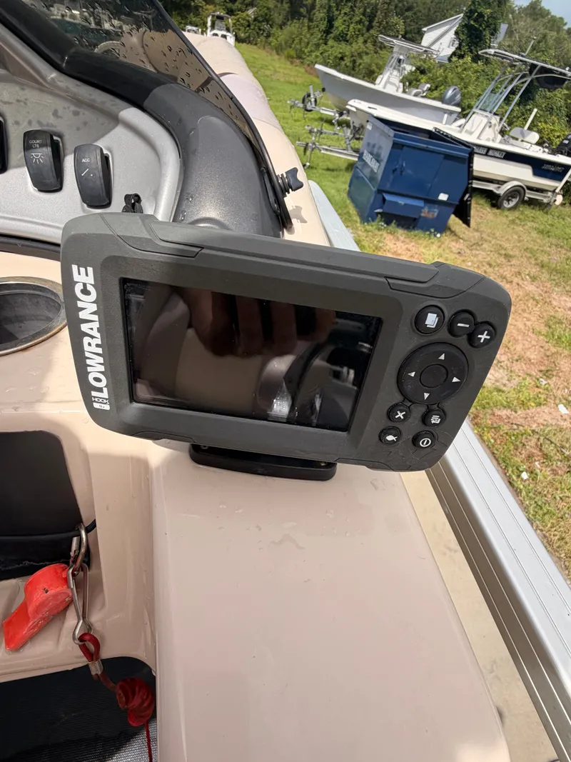 Slide: The Image of A Lowrance fish finder is mounted on a boat, with a helm station in the background. - 16