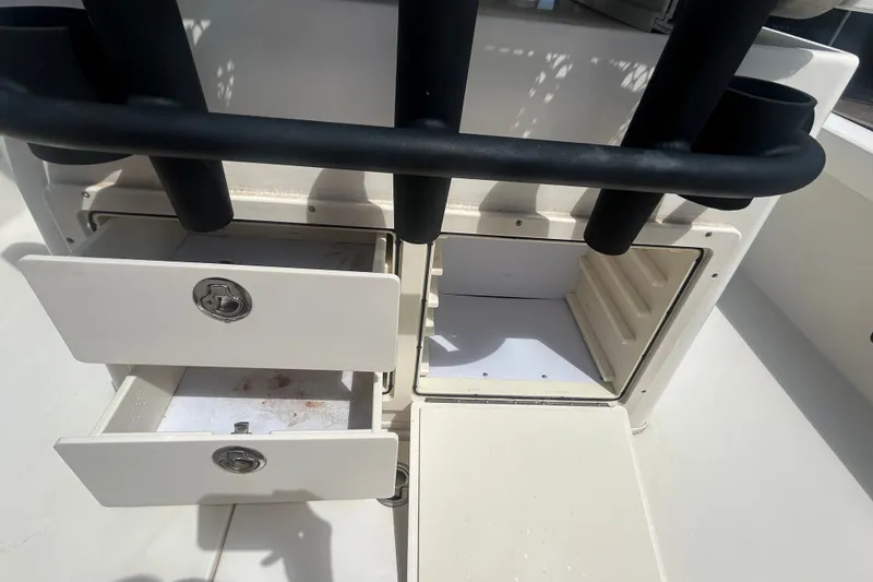 Slide: The Image of Open storage compartments on a 2013 Pathfinder 2300 HPS boat, featuring rod holders. - 16