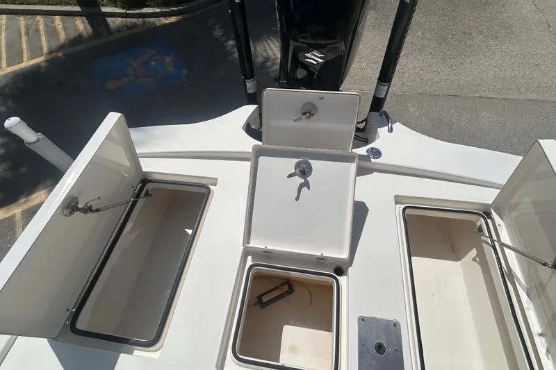 Slide: The Image of 2013 Pathfinder 2300 HPS boat with open storage compartments and visible engine. - 17