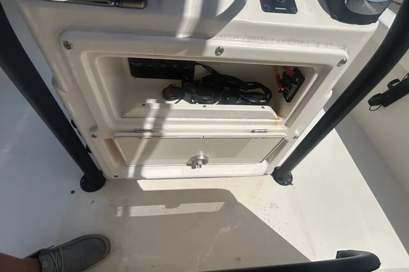 Slide: The Image of 2013 Pathfinder 2300 HPS boat console storage with electrical components and wiring. - 12