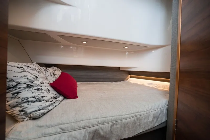 Slide: The Image of Cozy cabin interior of 2020 Tiara Sport 34 LS with plush bedding and ambient lighting. - 33